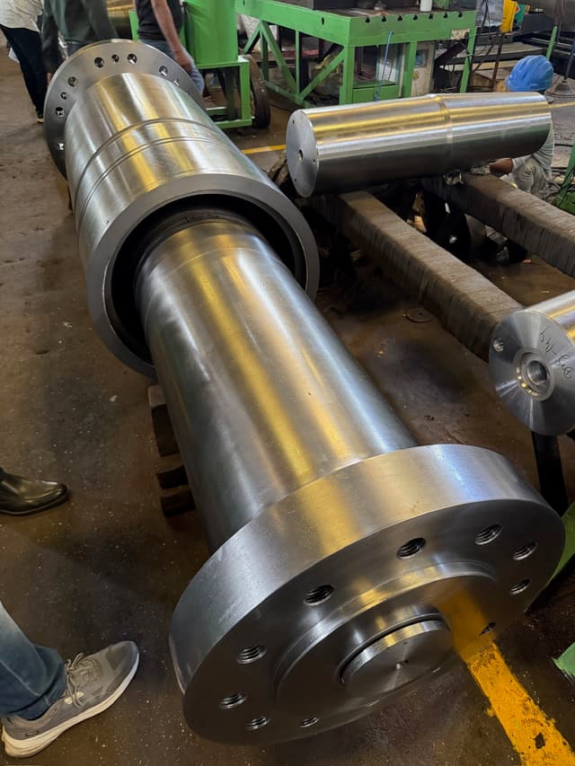 A hydro turbine shaft with an integral flange, turned and bored.