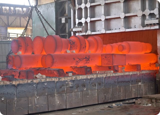 Forgings glowing in rows inside the bogie furnace during normalising.