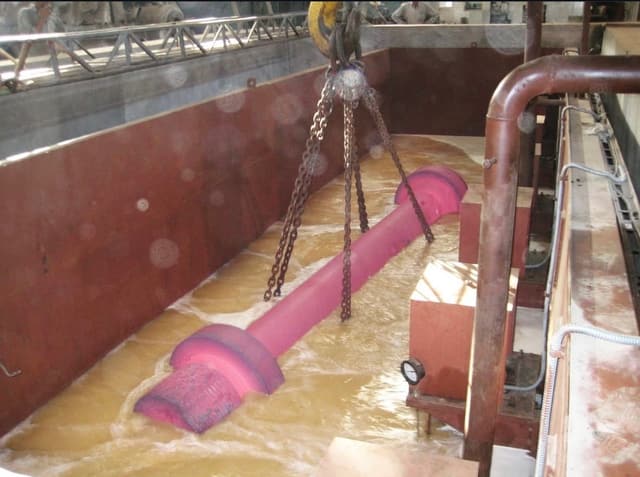 A bar at quenching heat lowered on chains into the polymer quench tank.