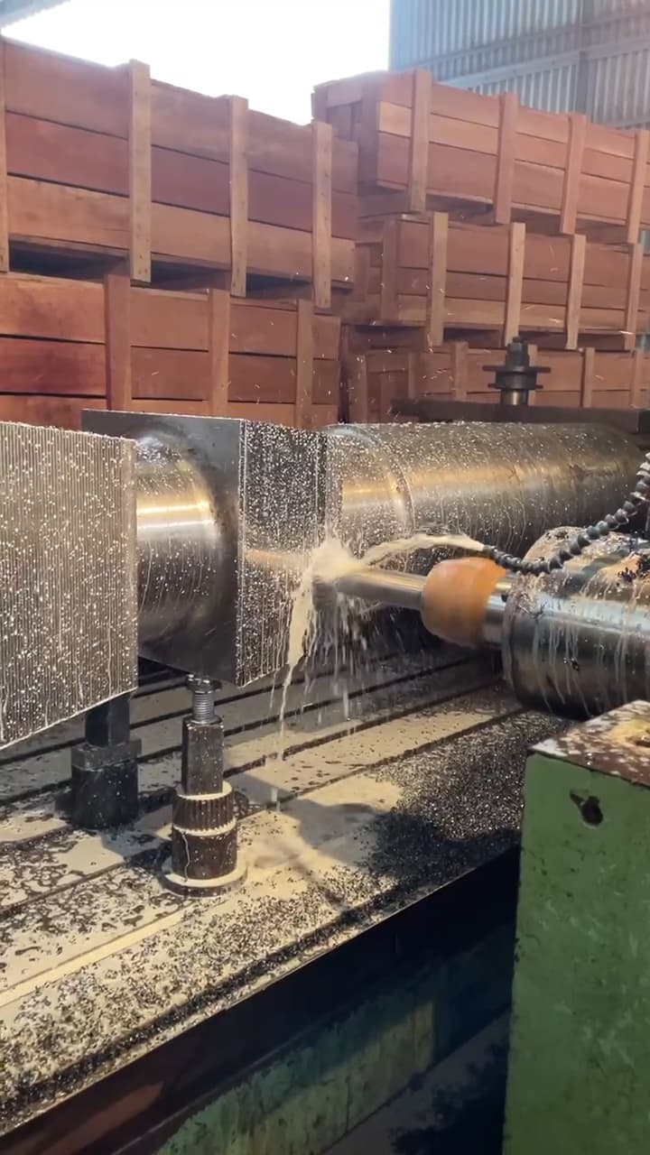 A shaft turning under the tool on the lathe, coolant running over the cut.